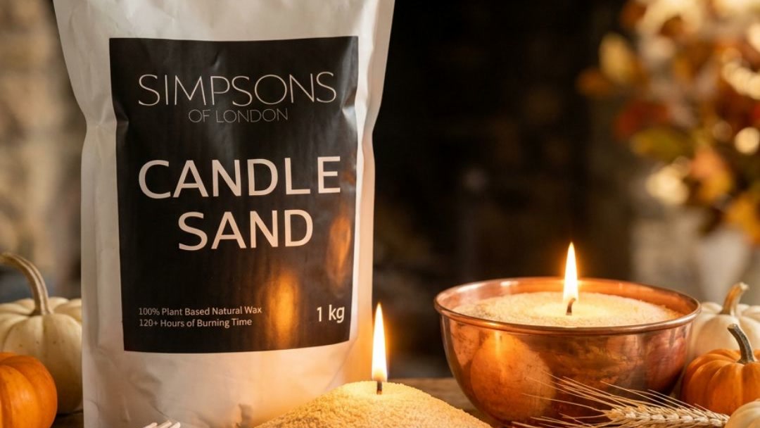 Candle sand burning in a copper vessel on an autumn mantelpiece with pumpkins and dried wheat