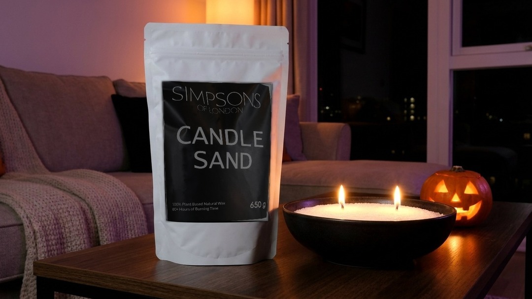 Cosy Halloween night in with a bowl of lit candle sand, the Simpsons of London white pouch and a small glowing jack-o'-lantern